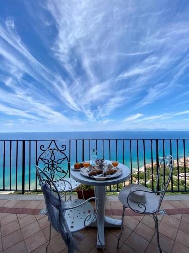 a table and chairs on a balcony with the ocean at Residenza Porta di Mare in Castellabate