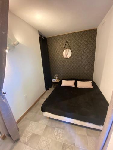 - une chambre avec un grand lit noir dans l'établissement Appart. F2 apercu Port de Santa Lucia St Raphaël, à Saint-Raphaël