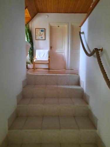 a staircase leading to a room with a white door at Anna vendégház in Tihany