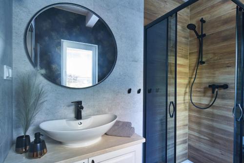 a bathroom with a sink and a mirror at SosnowoMi - Całoroczne domy na wynajem in Lubiatowo