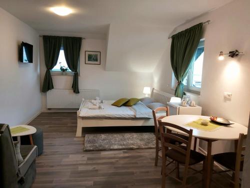 コレニツァにあるKataricaのベッド、テーブル、椅子が備わる小さな客室です。
