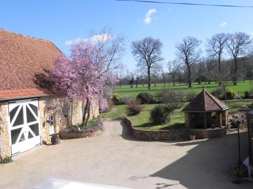 a garden with a stone building and a gazebo at Chambre d'hôtes Domaine de la Guinchère in LʼHôpital-le-Mercier