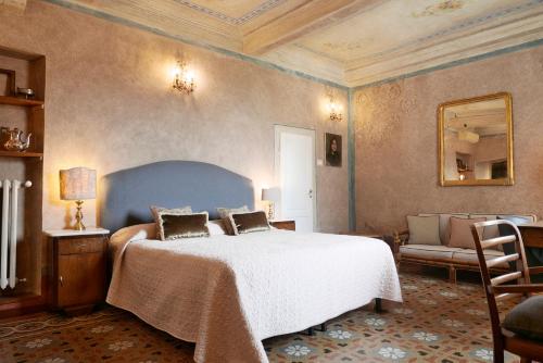 Un dormitorio con una cama, una silla y un espejo. en Appartamenti Oriuolo, en Florencia