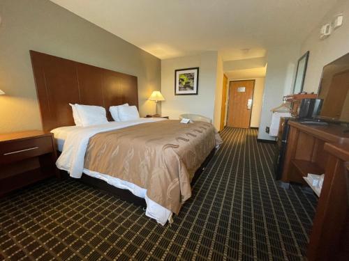a hotel room with a large bed and a television at Quality Inn Madison West Near University Area in Madison