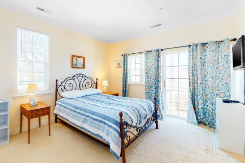 um quarto com uma cama e duas janelas com cortinas em Saint Louis Ave, Unit D em Ocean City