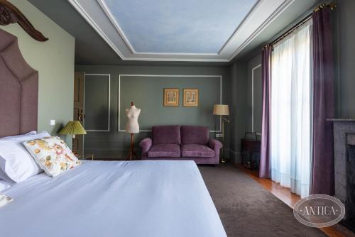a bedroom with a large bed and a couch at Casa Antiga in Porto