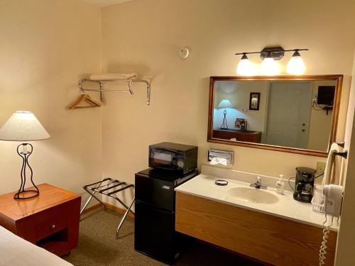 Whitetail Creek Resort في Lead: حمام مع حوض ومرآة