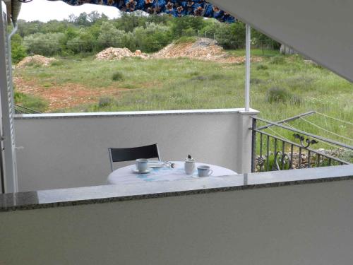 a balcony with a table with two cups on it at Apartment in Malinska II in Malinska