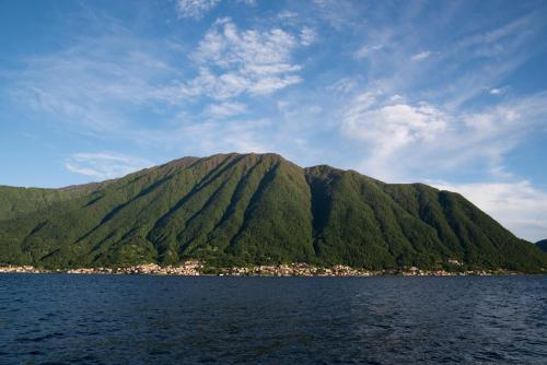 a mountain in the middle of a body of water at Mansarda I Cipressi in Lenno