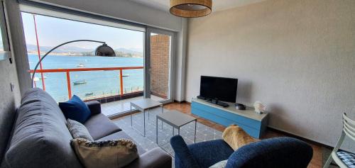 a living room with a couch and a large window at Vista Azul in Baiona