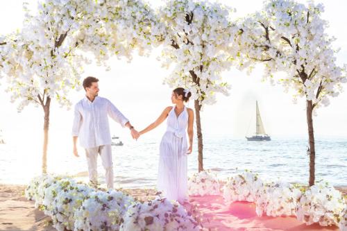 a bride and groom standing on the beach holding hands at Playa Los Arcos Hotel Beach Resort & Spa in Puerto Vallarta
