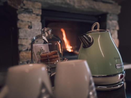 a tea kettle and some candles in front of a fireplace at B&B Ca' Mea room, wellness & food in Levata