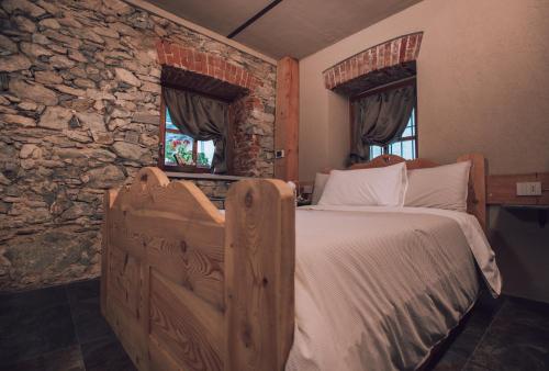 a bedroom with a large bed with a stone wall at B&B Ca' Mea room, wellness & food in Levata