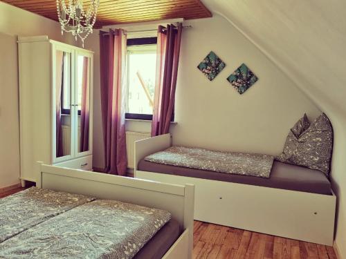 um quarto com 2 camas e uma janela em Bonnys Ferienwohnung em Nohfelden