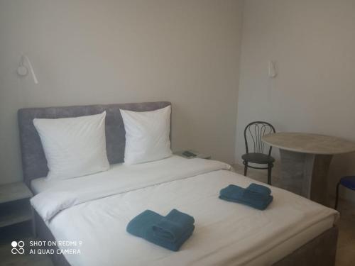 Нова і затишна квартира у центрі في أوجهورود: سرير وفوط زرقاء فوقه