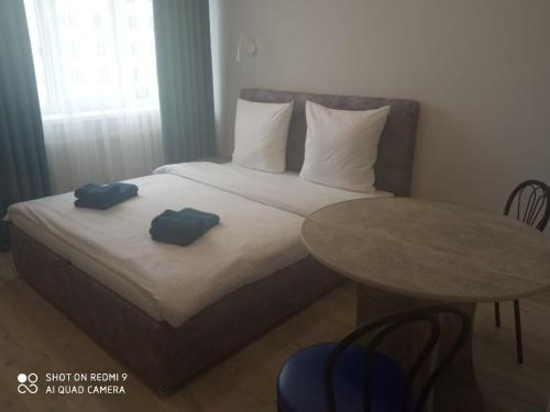 Нова і затишна квартира у центрі في أوجهورود: سرير عليه وسادتين بجانب طاولة