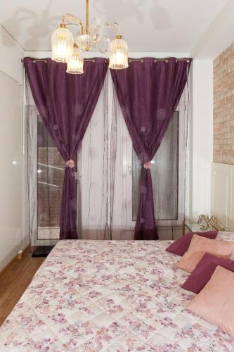 a bedroom with a large bed with purple curtains at Appartamento Piera Rossa in Venice