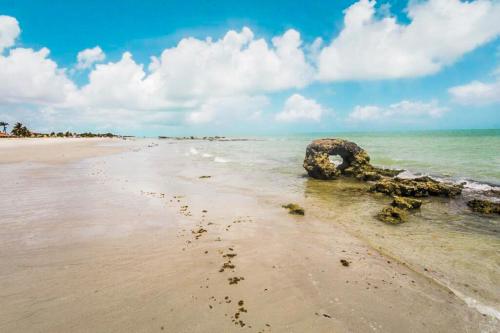 a beach with a boat in the water at Pousada Ciranda in Itamaracá