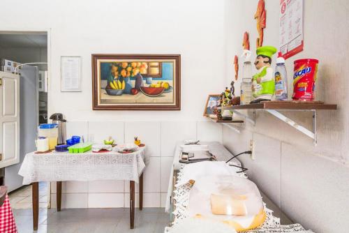 a kitchen with a table and a counter with food on it at Pousada Ciranda in Itamaracá