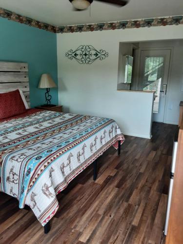 a bedroom with a bed and a wooden floor at Horseshoe Riverside Lodge in Canyon Lake
