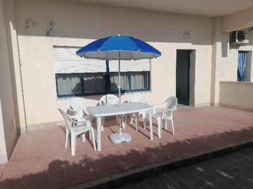 a table and chairs with an umbrella on a patio at Zibibbo Beach Apartments - Trapani in Trapani