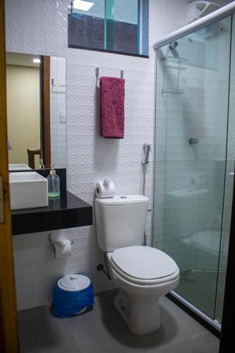 a bathroom with a toilet and a glass shower at Chalé Ribeirão do Meio in Lençóis
