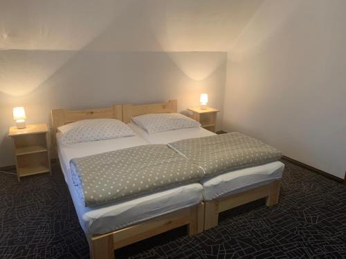 a bedroom with two beds and two lights on the wall at Łomniczanka in Karpacz