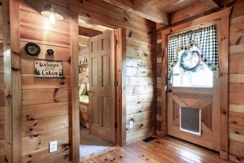 a log home hallway with wooden walls and a door at Bear Claw Cove - hot tub, jacuzzi, fireplace, view in Sevierville