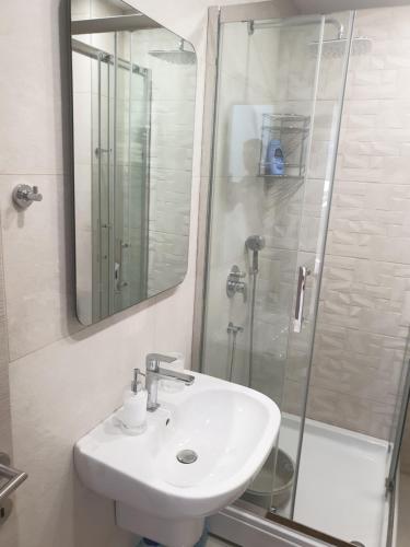 uma casa de banho branca com um lavatório e um chuveiro em Apartment Marta 2 em Kotor
