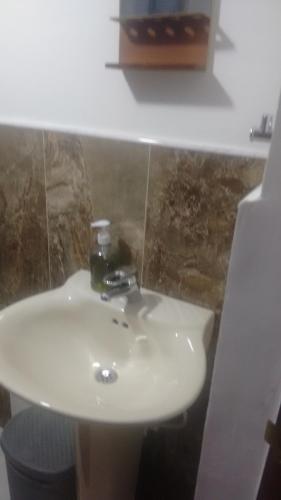 a bathroom with a white sink and a toilet at Hostal central villa rosita in Villa de Leyva