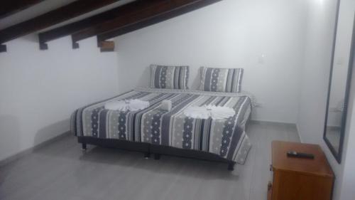 a bed with two pillows in a white room at Hostal central villa rosita in Villa de Leyva