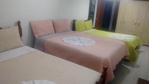 a room with three beds in a room at Hostal central villa rosita in Villa de Leyva