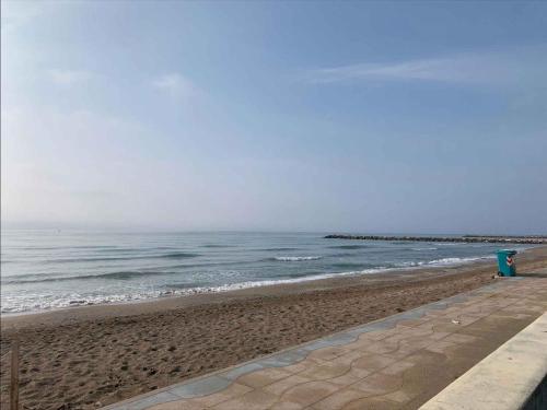 a beach with a blue bench and the ocean at Apartment in Eraclea Mare 40761 in Eraclea Mare