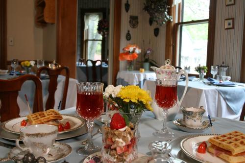 a table with plates of food and two glasses of juice at The Governor's Inn in Ludlow