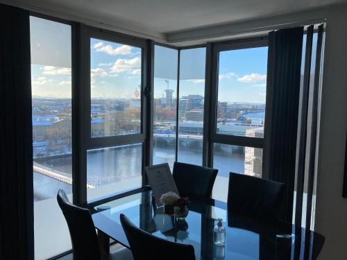 a dining room with a table and a view of a bridge at Riverside Apartments in Glasgow
