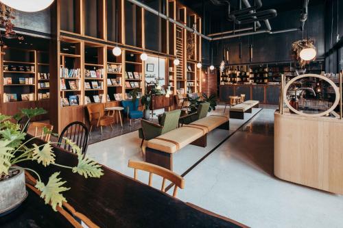 台南市にあるU.I.J ホテル ＆ ホステルの多数の椅子とテーブルが並ぶ図書館