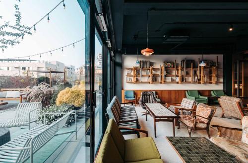a room with chairs and tables on a balcony at U.I.J Hotel & Hostel in Tainan
