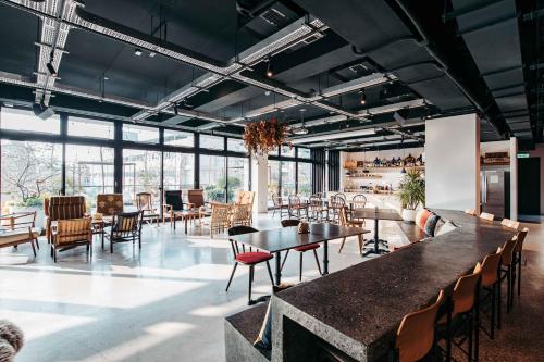 a large room with tables and chairs and windows at U.I.J Hotel & Hostel in Tainan