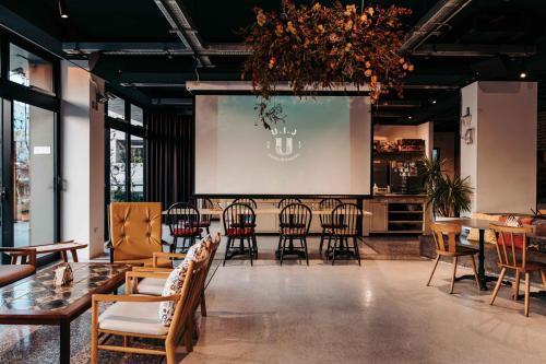 a large room with chairs and tables and a screen at U.I.J Hotel & Hostel in Tainan