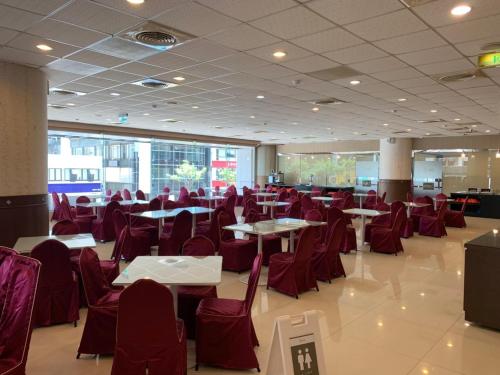 a restaurant with red chairs and tables in a room at Hu House in Kaohsiung