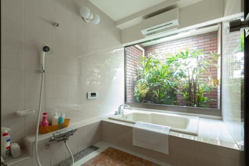 łazienka z wanną i oknem w obiekcie KB1*Unique HUGE house for family /JR +subway w Osace