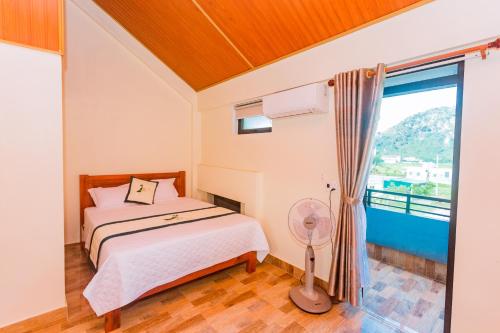 a bedroom with a bed and a large window at Phong Nha Green Homestay in Phong Nha