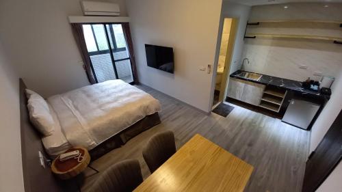 einen Blick über ein Schlafzimmer mit einem Bett und einem Tisch in der Unterkunft 航空棧輕旅民宿 in Huxi
