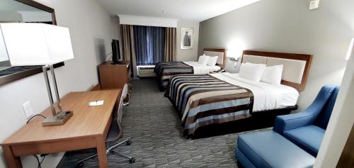 a hotel room with two beds and a desk and a chair at Spark By Hilton Tupelo in Tupelo