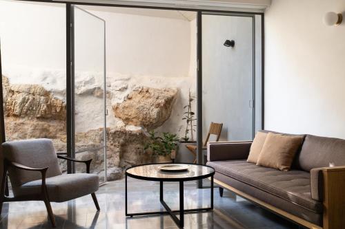 a living room with a couch and a table at Khan Ein Karem Boutique Hotel in Jerusalem