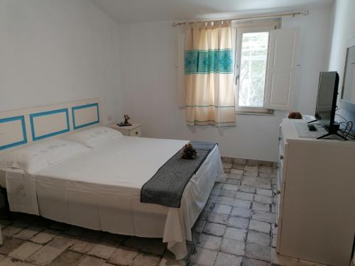 een slaapkamer met een groot bed en een televisie bij Casa Contadina in Oristano
