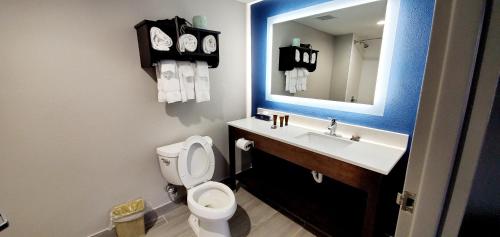 a bathroom with a toilet and a sink with a mirror at Spark By Hilton Tupelo in Tupelo
