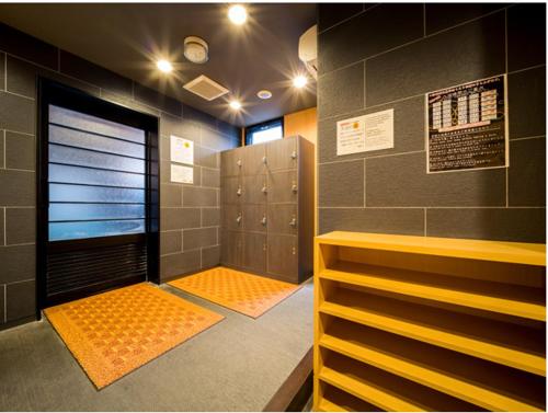 Super Hotel Yonago Ekimae في يوناغو: غرفة خزانة مع خزائن وخزانة