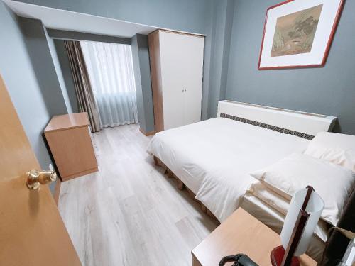 Кровать или кровати в номере Hotel Nikko Apartment Dalian