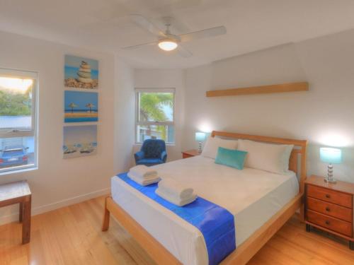 a bedroom with a bed and a blue chair at Maggies Beachfront Apartment 4 in Horseshoe Bay
